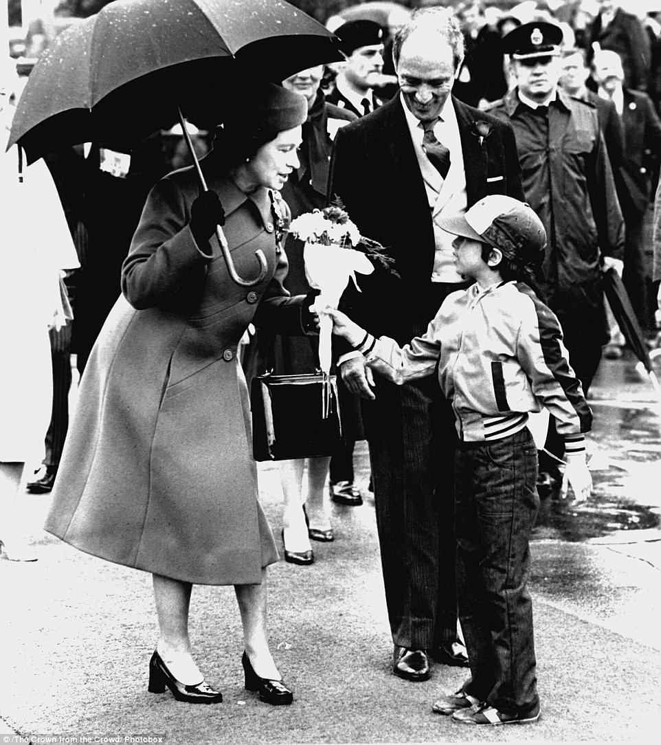 Nữ hoàng Elizabeth II nhận hoa từ cậu bé Andrew Morris, 8 tuổi. Bức ảnh ấn tượng này được chụp năm 1982.
