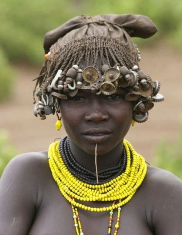 Trong khi đó, phụ nữ ở Châu Phi thường làm kiểu tóc tết để đeo được nắp chai và hạt gỗ trang trí trên đầu. Ảnh oddee.