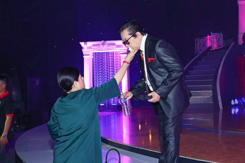 Bà xã Elvis Phương chăm sóc chồng chu đáo từ việc trang điểm đến lấy nước, thức ăn cho chồng. Ảnh: Người Lao Động.