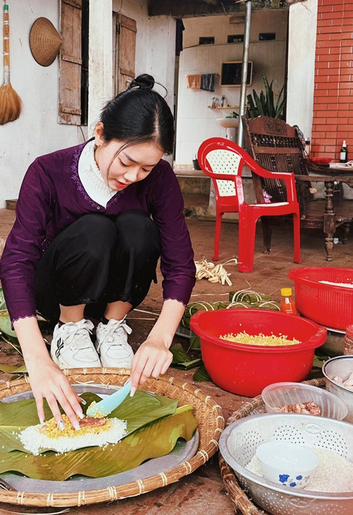 Khánh Linh để mặt mộc, gói bánh chưng dịp Tết. Ảnh: FBNV.