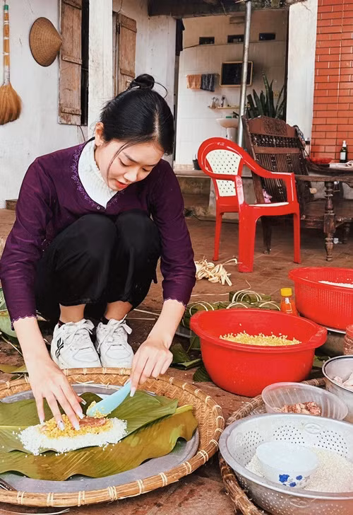 Khánh Linh để mặt mộc, gói bánh chưng dịp Tết. Ảnh: FBNV.