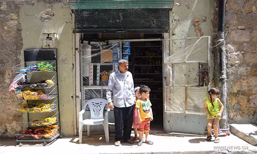 Ông Muhammad và các cháu đứng trước cửa hàng ở Ansari ngày 28/7. Ảnh: THX.