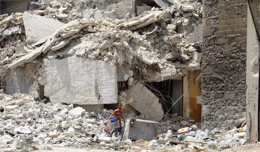 Người đàn ông tìm kiếm những vật dụng còn dùng được giữa đống đổ nát ở khu Ansari, Đông Aleppo, ngày 28/7. Ảnh: THX.