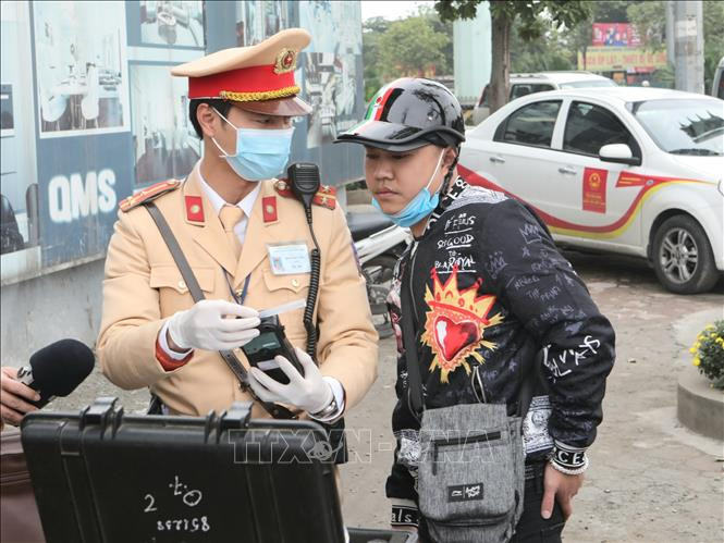 Cảnh sát giao thông Hà Nội kiểm tra trang thiết bị sử dụng phương tiện an toàn kiểm tra nồng độ cồn trong khí, đeo khẩu trang y tế trước khi làm nhiệm vụ.