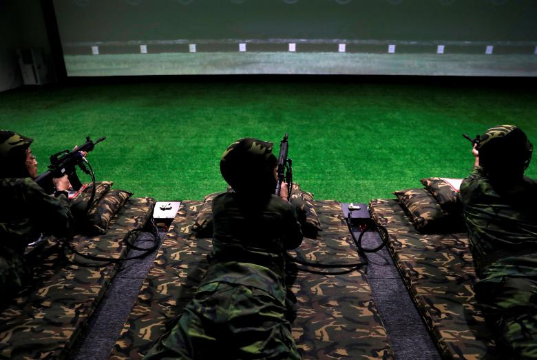 Du khách tham gia trò chơi bắn súng điện tử trong một khu vui chơi ở Kim Môn.