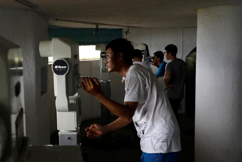 Các du khách đến từ Trung Quốc đại lục nhìn về phía thành phố Hạ Môn (Trung Quốc) qua ống nhòm tại căn cứ quân sự cũ trên quần đảo Kim Môn.