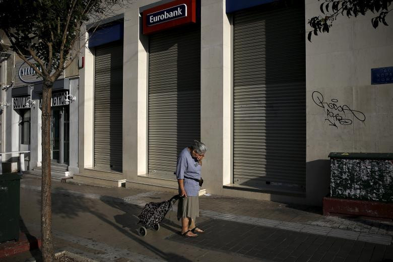 Người phụ nữ đi qua một chi nhánh của ngân hàng Eurobank bị đóng cửa ở Athens ngày 29/6/2015.