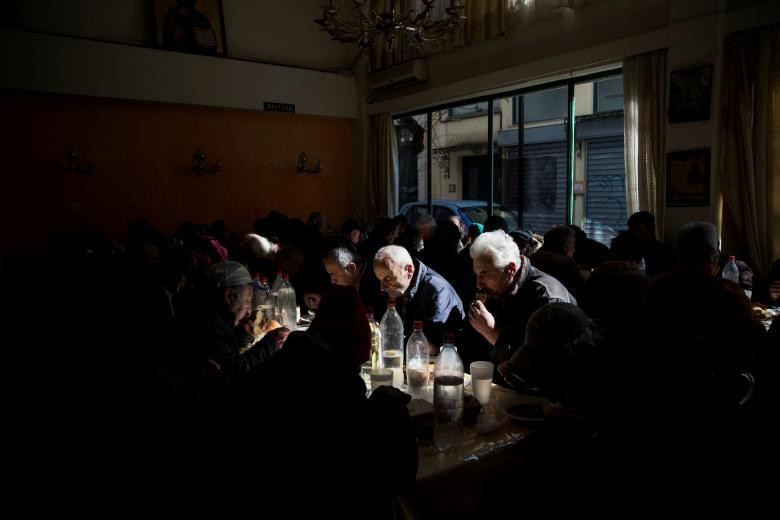 Người dân ngồi ăn trong nhà bếp của một nhà thờ ở thủ đô Athens ngày 15/2/2017.