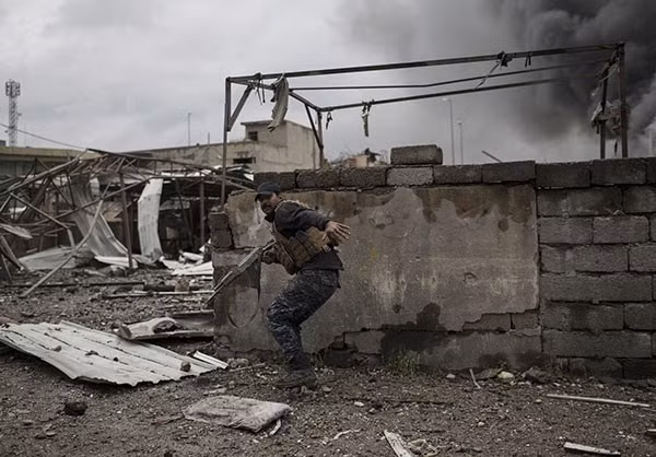 Một người lính đặc nhiệm Iraq tháo chạy trong lần đụng độ với khủng bố IS trong chiến dịch giải phóng tây Mosul. Ảnh FNA