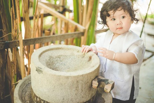 Diện áo bà ba tạo dáng bên đôi quang gánh mộc mạc, bé gái Mimi "ra dáng" bác nông dân chính hiệu.