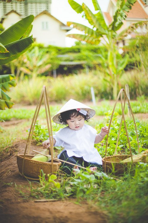 Mũm mĩm và bụ bẫm, cô bé tóc xoăn vẫn rất dễ thương trong tấm áo bà ba trắng vừa vặn.