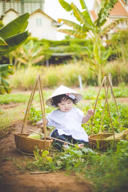 Mũm mĩm và bụ bẫm, cô bé tóc xoăn vẫn rất dễ thương trong tấm áo bà ba trắng vừa vặn.