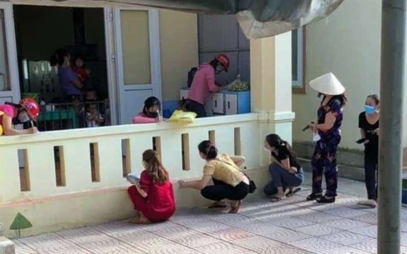 Đưa con đến trường vẫn không yên tâm nên phải "rình mò" từ xa như thế này đây. Ảnh: Tổng hợp