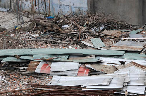 Nhiều mái tôn, gạch tường... đổ sập vẫn còn nằm ngỗn ngang.