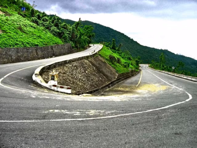 Đường lên đèo Cả uốn lượn như dải lụa giữa màu xanh của núi rừng, có những khúc quanh tưởng chừng như không thể bẻ tay lái.