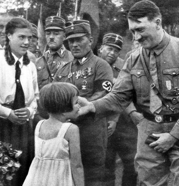 Hitler tươi cười, nựng má một bé gái trong một sự kiện.