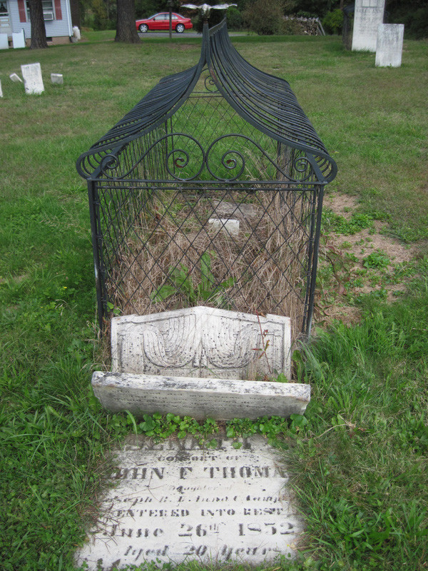 Ngôi mộ được bọc lồng sắt còn lại khắc tên Asenath Thomas. Bà qua đời năm 1852 và là vợ ông John F. Thomas.