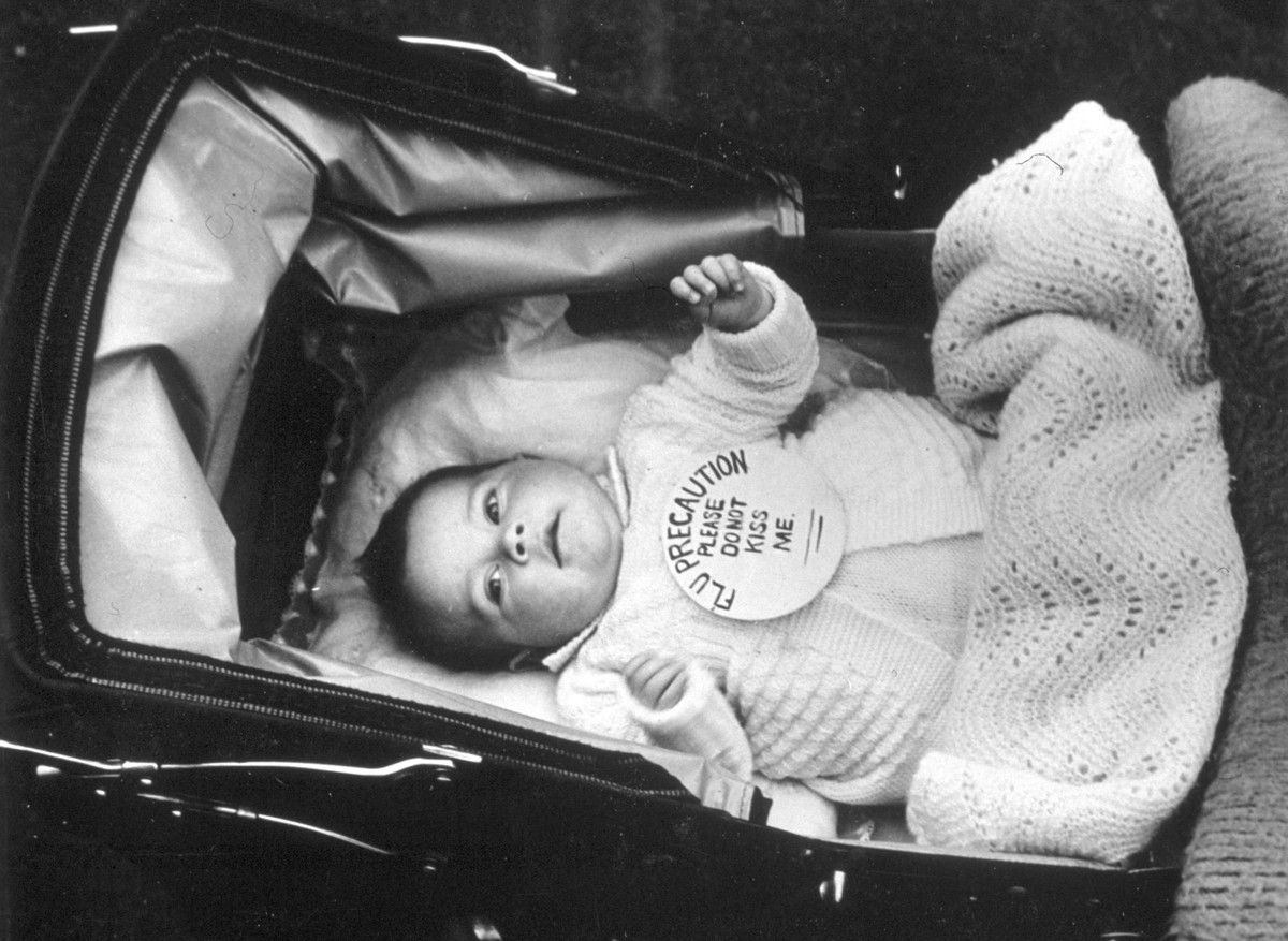 Do đại dịch cúm dễ lây từ người sang người nên trẻ em có nguy cơ lây nhiễm cao. Vì vậy, trẻ em được bảo vệ bằng cách đặt một tấm biển trên người đề nghị mọi người không hôn bé.