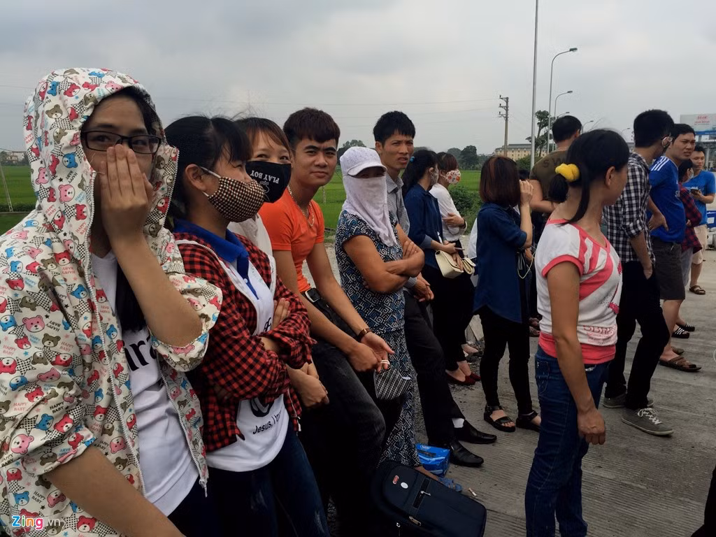 Hàng chục hành khách đứng ngoài trời sau khi cảnh sát hạ tải toàn bộ 64 người trên xe khách Nam Định.