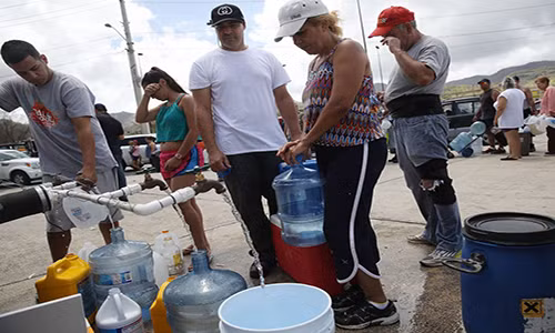 Cư dân xếp hàng lấy nước ở Aibonito. Ảnh: BI.