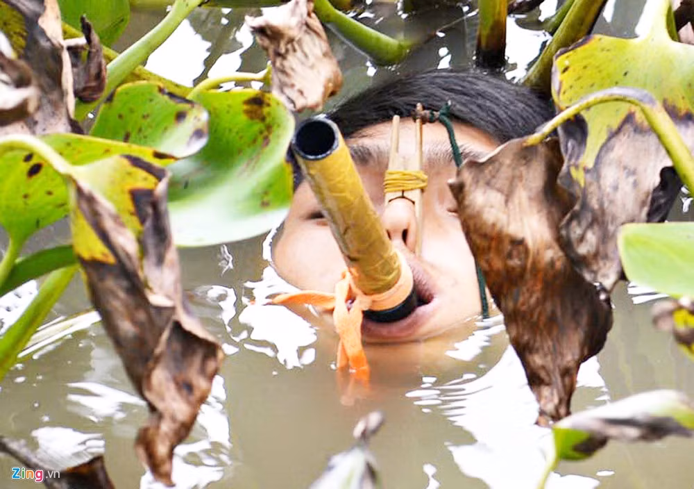 Trước khi giấu mình, chiến sĩ đặc công dùng dụng cụ kẹp mũi để nước không tràn vào.