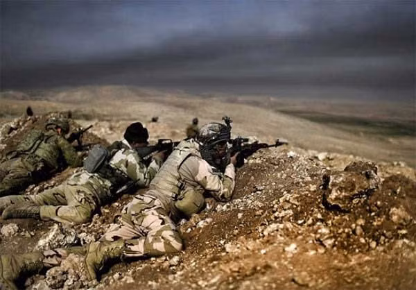 Các binh sỹ thuộc biên chế Sư đoàn 9 quân đội Iraq đang theo dõi qua ống nhòm để xác định mục tiêu. Họ đang tiến công nhằm cắt đứt tuyến đường nối giữa Tây Mosul và thị trấn Tal Afar mà phiến quân IS đang nắm giữ. Ảnh FNA