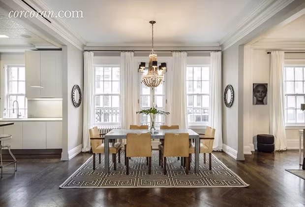 Phòng ăn nổi bật với đèn chùm và tấm thảm hoa văn đen trắng. 