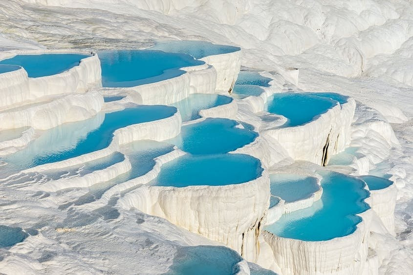 3. Hierapolis-Pamukkale (Turkey). Dường như không có gì mới về thủy liệu pháp. Quay trở lại khoảng năm 130 TCN, thị trấn Herapolis (Thành phố linh thiêng) của Hy Lạp - La Mã là một điểm đến spa và nó sẽ vẫn tồn tại trong một vài thế kỉ bởi một lý do: vùng nước khoáng nhiệt gần đó (Cung điện Bông hoặc Lâu đài Bông) với cảnh quan kì lạ của những bậc thang nơi lưu vực và thác nước hóa đá. Một hệ thống kênh đào đã được xây dựng với diện tích lớn đã không chỉ đưa nước đến để phục vụ cho việc tắm rửa của người dân mà còn để họ sử dụng để tưới tiêu cho những cánh đồng. Nhà hát cổ ở đây - một trong những nơi được bảo tồn tốt nhất trên thế giới, là nơi để tổ chức các trận đấu cho những đấu sĩ thời La Mã.