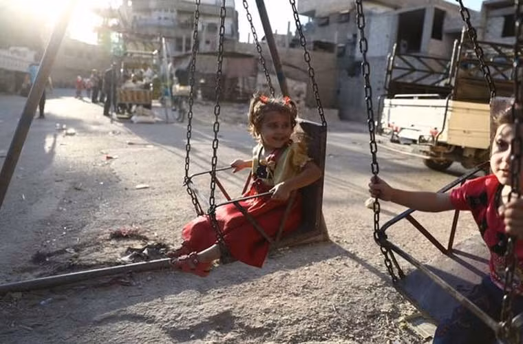 Các bé gái Syria đáng thương đang chơi ở một góc phố để ăn mừng lễ Al-Adha bước sang ngày thứ ba.