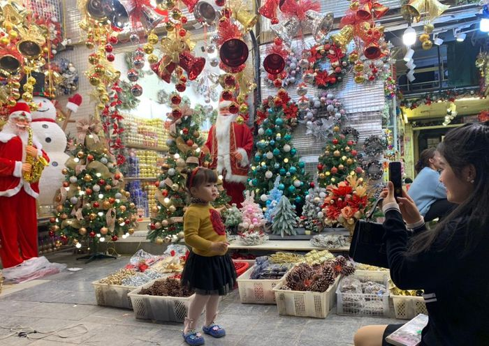 Các em nhỏ cũng được gia đình đưa đến Hàng Mã dạo chơi và tranh thủ chụp ảnh bên những cửa hàng lung linh đồ Giáng Sinh.