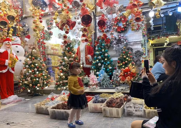 Các em nhỏ cũng được gia đình đưa đến Hàng Mã dạo chơi và tranh thủ chụp ảnh bên những cửa hàng lung linh đồ Giáng Sinh.