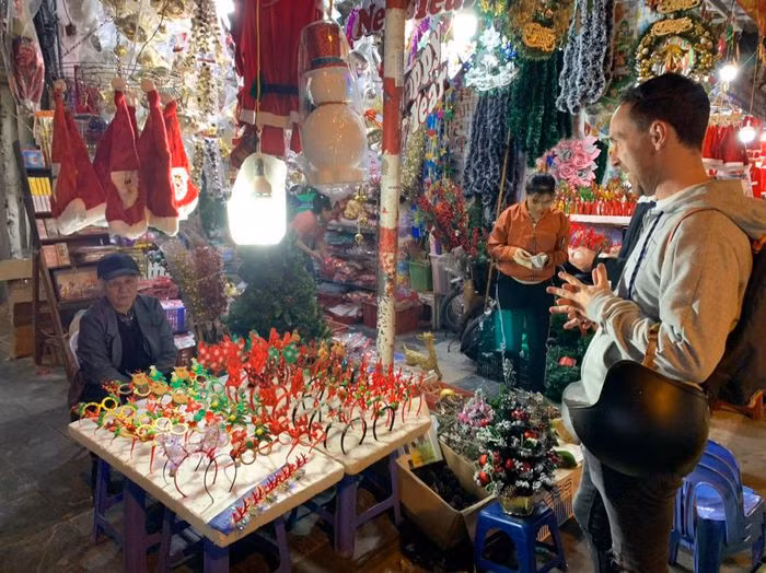 Du khách nước ngoài thích thú với những món đồ đẹp và độc đáo được chủ các cửa hàng trưng ra mặt tiền.