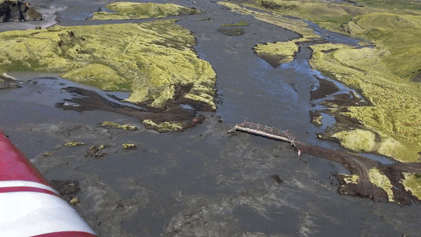 Đúng lúc chiếc máy bay nghiêng mình, một cơn gió mạnh đã thổi tới và cuốn bay chiếc iPhone này ra khỏi tay chủ nhân của mình, rơi từ độ cao 60m xuống thẳng vùng đất đá lởm chởm bên dưới, vốn đang bị cơn lũ quét qua và phá vỡ các con đường.