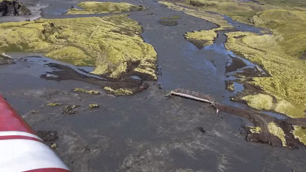 Đúng lúc chiếc máy bay nghiêng mình, một cơn gió mạnh đã thổi tới và cuốn bay chiếc iPhone này ra khỏi tay chủ nhân của mình, rơi từ độ cao 60m xuống thẳng vùng đất đá lởm chởm bên dưới, vốn đang bị cơn lũ quét qua và phá vỡ các con đường.