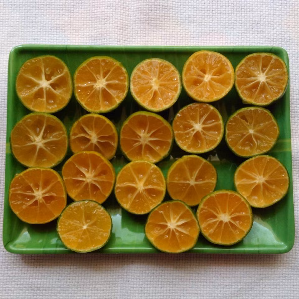 Bước 2: Cắt đôi quả tắc, bỏ hết hạt.