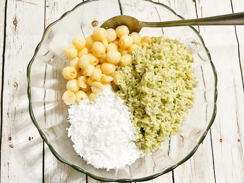 Đổ gạo ra cho ráo nước rồi cho vào tô, thêm hạt sen, một chút muối, vụn cơm dừa hoặc dừa bào sợi sau đó trộn đều nguyên liệu.