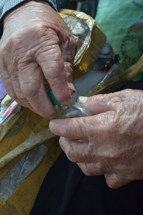 Kèm theo đó là chai dầu gió đã sắp hết hạn sử dụng, và chiếc ống ngoáy trầu đậm màu thời gian. 