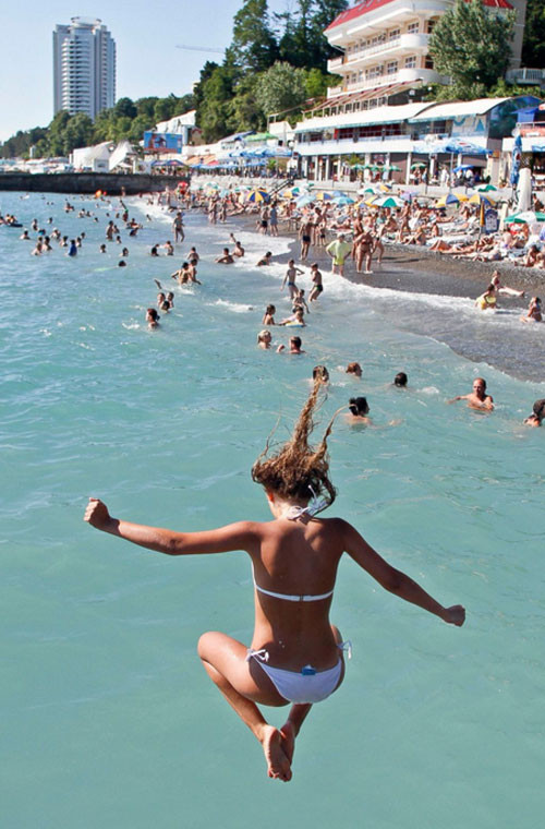 Một cô gái nhảy xuống nước khi đi tắm biển.