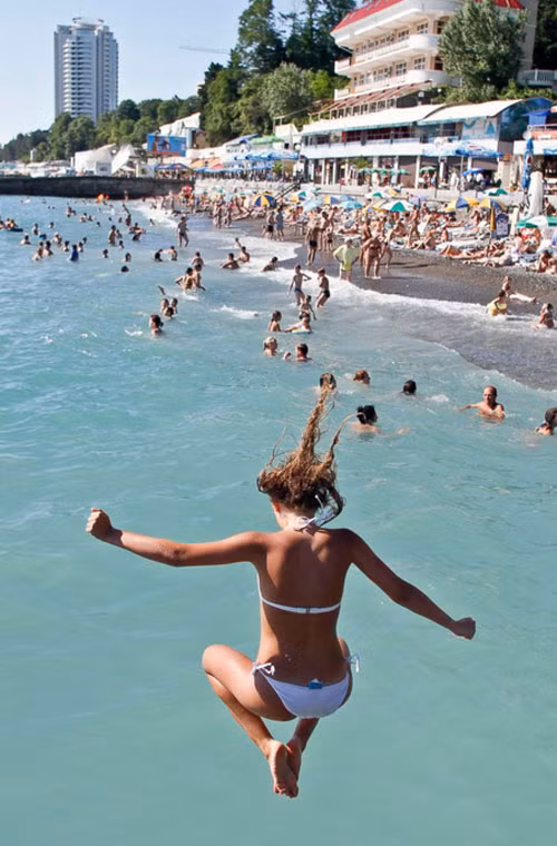 Một cô gái nhảy xuống nước khi đi tắm biển.