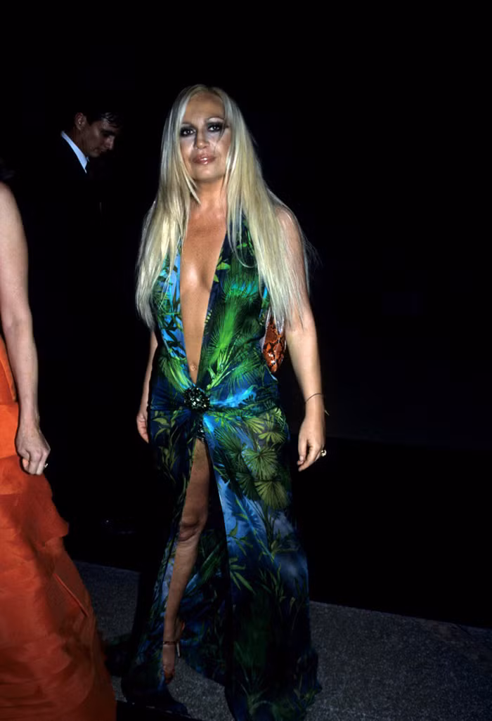 “Mẹ đẻ” của mẫu váy – Donatella Versace cũng từng lên đồ sản phẩm do chính mình thiết kế tại Met Gala 1999. Phần tà được giữ ngắn giống như phiên bản gốc song lại được cách điệu hở cánh tay. Ảnh: Biography.