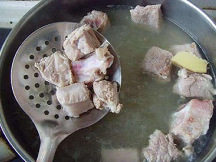 Xong công đoạn chần, đun nóng dầu hạt cải rồi cho gừng hoặc hoa hồi vào phi dậy mùi thơm. Đợi sườn có cạnh ngả vàng thì chế nước ấm ngập tối thiểu 3cm.