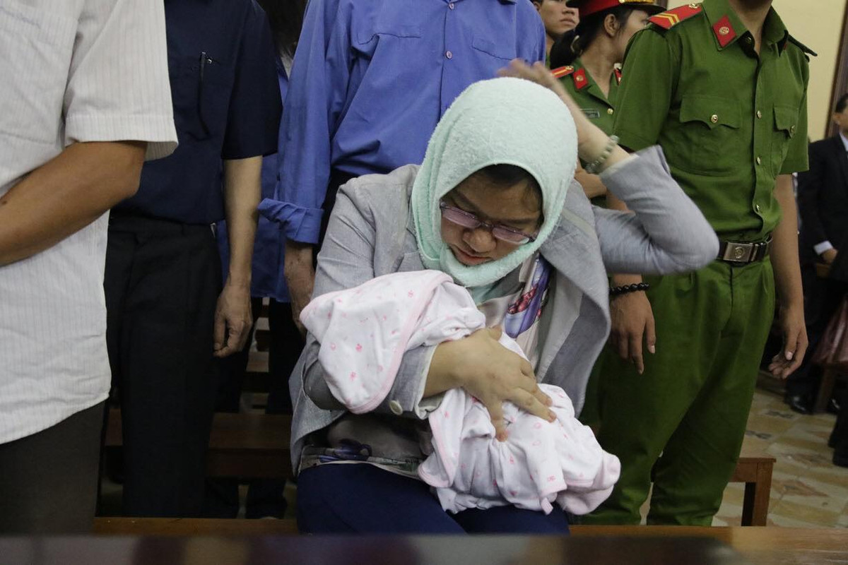 Bị cáo Loan ẵm con tới dự tòa sáng nay.