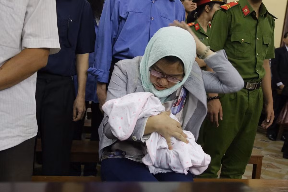 Bị cáo Loan ẵm con tới dự tòa sáng nay.