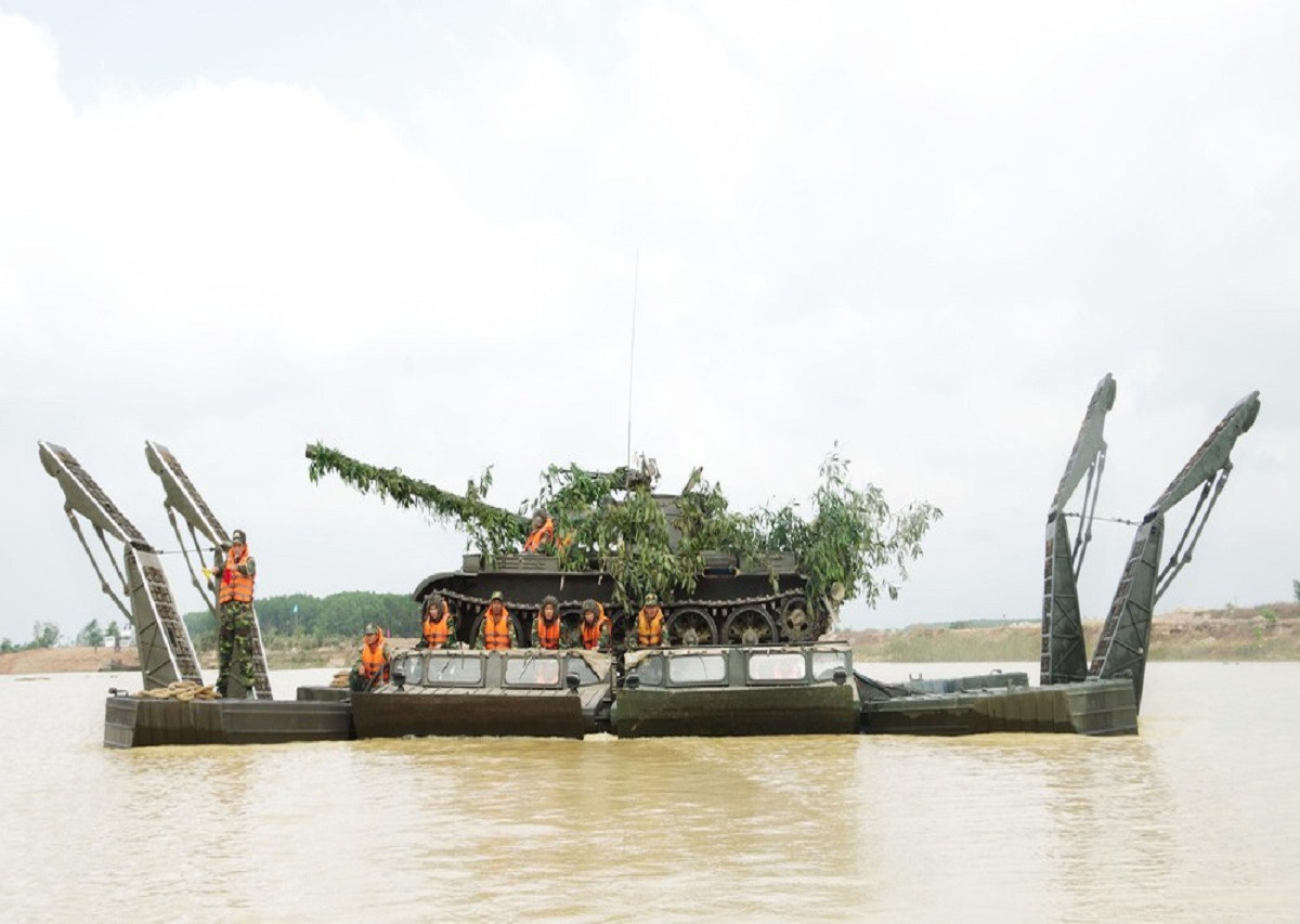 Tuy nhiên, việc phải mất từ 15-30 phút cho việc lắp đặt ống thông hơi tác động không hề nhỏ đến tốc độ hành quân tác chiến của một đơn vị tăng thiết giáp, đó là còn chưa kể đến những rủi ro có thể xảy ra trong quá trình T-55 vượt sông bằng ống thông hơi khi chúng không thực sự đáng tin cậy. Và để giải quyết vấn đề này các thiết kế sư Liên Xô đã cho ra đời phà tự hành và cầu phao tự hành. Nguồn ảnh: QĐND.