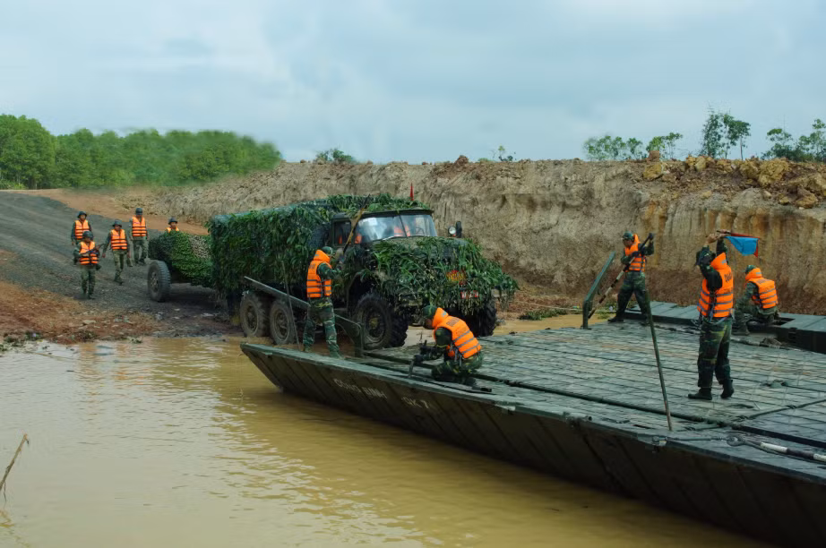 Trong ảnh là hai mảng cầu phao PMP được sử dụng như một phà tự hành giúp các phương tiện cơ giới có trọng tải lớn từ 20 tấn tới 50 tấn vượt sông với sự hỗ trợ của canô công binh BMK-150, tuy nhiên tốc độ di chuyển của PMP khá chậm khi phải vận chuyển cùng lúc nhiều phương tiện. Nguồn ảnh: Báo Quân khu 7.