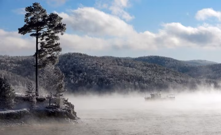 Xuồng máy chạy dọc theo sông Yenisei ở khu vực rừng Taiga ở Siberia nước Nga lúc nhiệt độ không khí là âm 19 độ C.