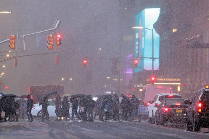 Người đi bộ và xe cộ trong cơn bão tuyết ở khu vực Quảng trường Thời Đại ở New York vào buổi tối 15/11.