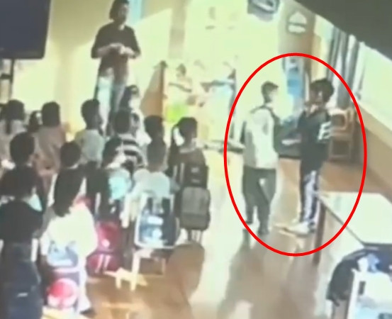 Đoạn video camera giám sát trong lớp học ghi lại, cho thấy một bé trai đứng trước lớp, vẻ mặt sợ hãi. Giáo viên với thái độ nghiêm khắc đã ra lệnh cho các học sinh khác lần lượt tiến đến và tát cậu bé.