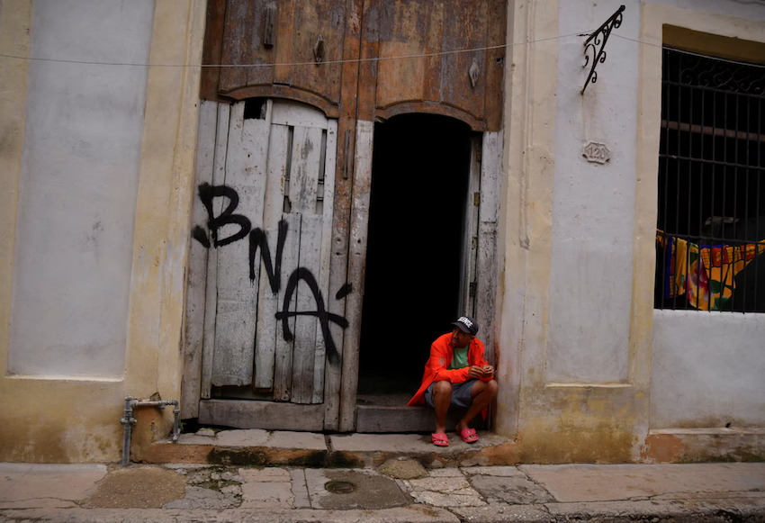 Yeslandys Carrion ngồi bên ngoài nhà của mình trong lúc mất điện tại Havana, Cuba, ngày 19/10. Ảnh: Reuters.