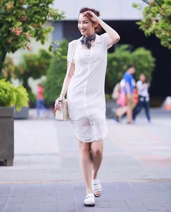 Trúc Diễm diện đầm sơmi (shirtdress) xuyên thấu cùng sandals quai ngang tiệp màu trắng và khăn quàng cho buổi dạo phố ngày đẹp trời.